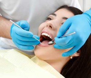 Dentist checking patient's mouth with dentist equipments
